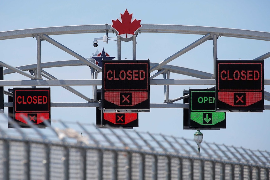 The Canadian-US border with closed signs above car lanes