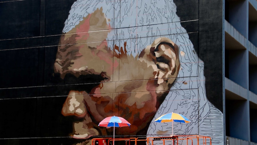 A portrait of Gurrumul in Darwin's Austin Lane, painted by Andrew Bourke.