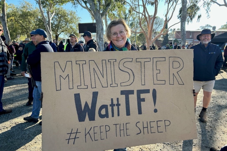 A woman holds a sign saying minister watt TF 