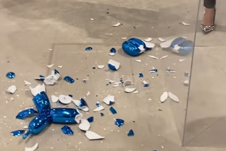 A screengrab from a video showing the aftermath of the smashed Jeff Koons dog sculpture, with blue shards everywhere.