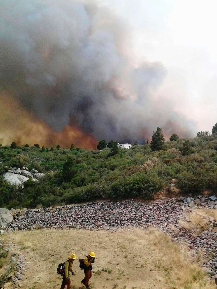 Arizona firefighters move away from a wildfire near the town of Yarnell