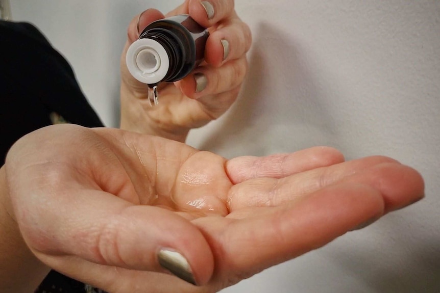 Lavender oil customer pours a few drops into their palm