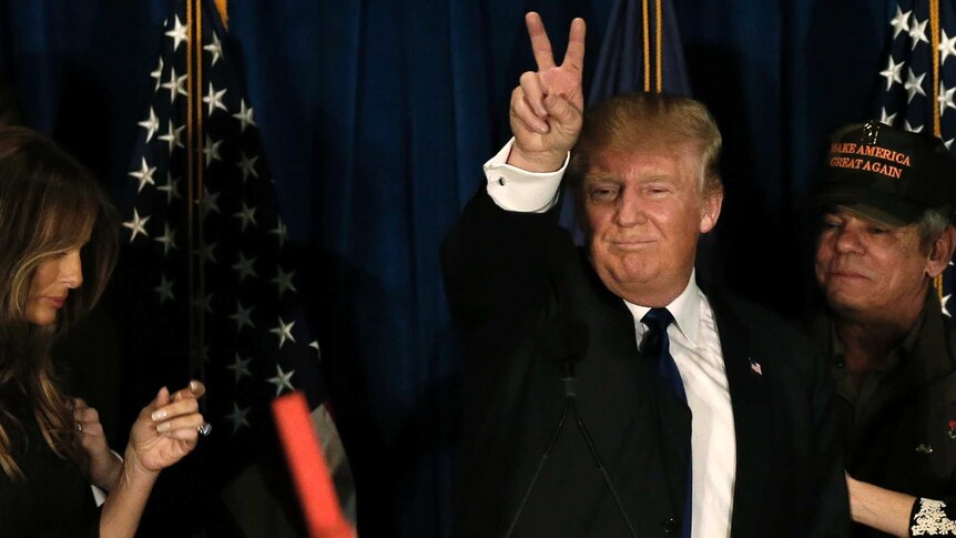 Donald Trump gives the peace symbol.