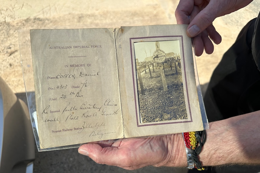 A sepia photo of a war grave in a faded paper folder. 