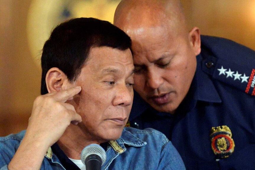 Rodrigo Duterte listens to Philippine National Police Director General Ronald Dela Rosa.