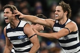 Two Geelong AFL players celebrate a goal against Carlton.