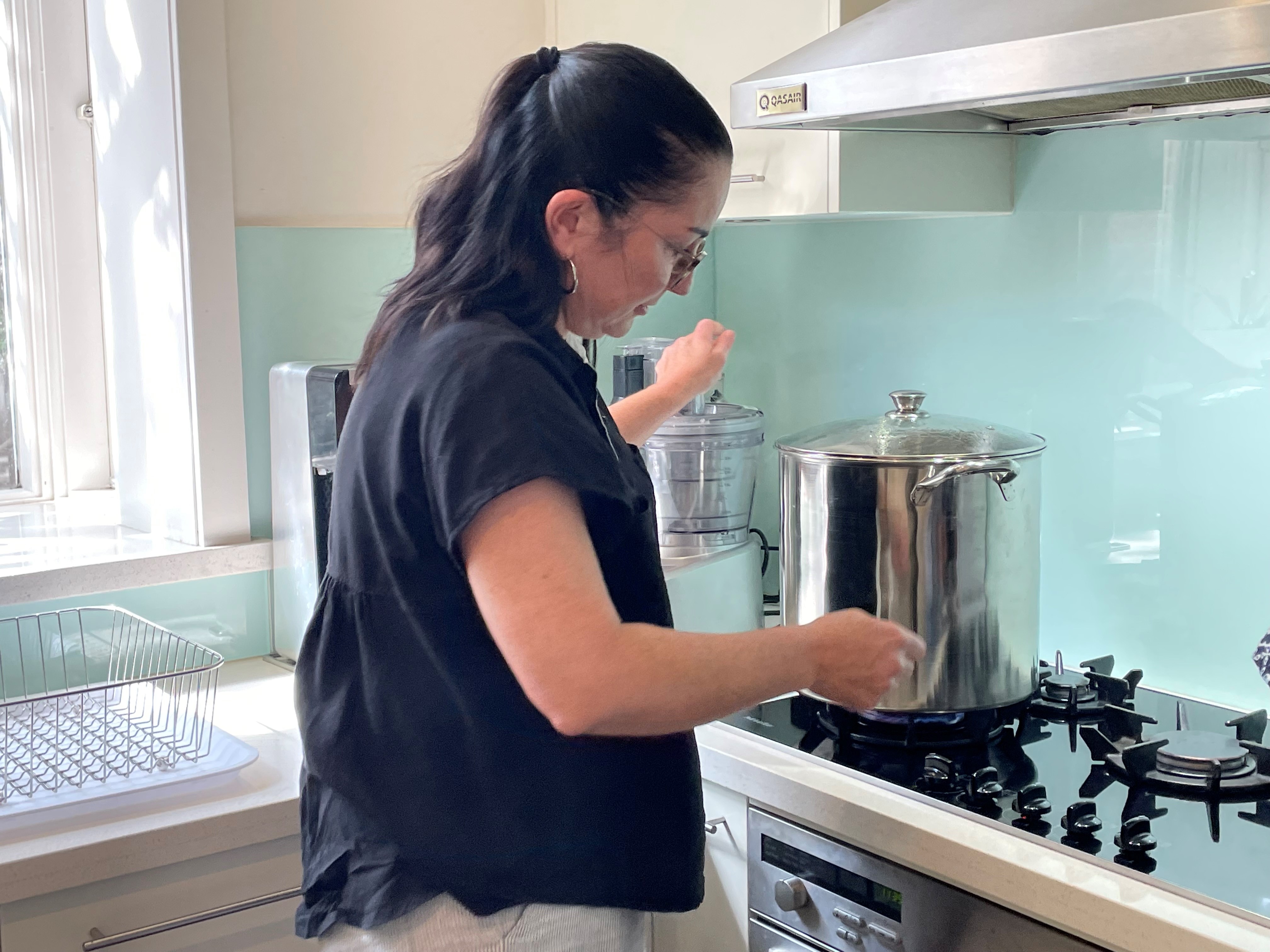 Brigid lighting up her gas stove to boil a huge pot of water at her home in Melbourne.