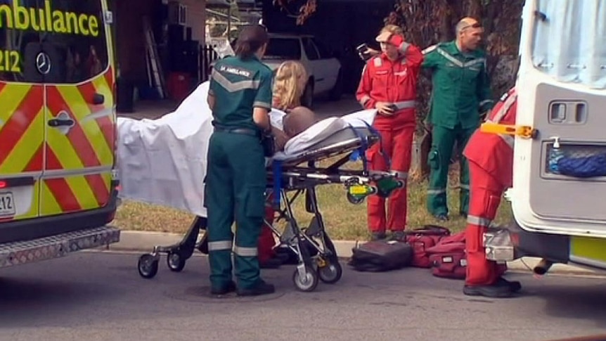 A man is treated by ambulance staff after a house fire.