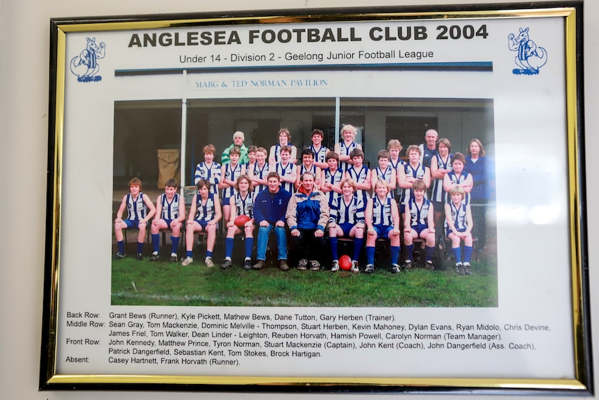 Gold photo frame with picture of a junior boys football team seated and smiling. Their names are written at the bottom.