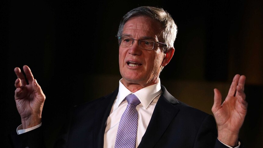 A headshot of Mike Nahan against a black background.