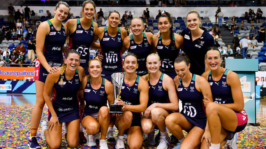 Melbourne Vixens players pose with the Super Netball preseason trophy.