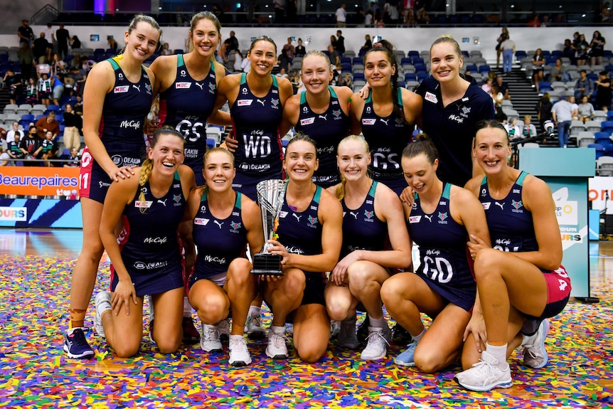 Melbourne Vixens players pose with the Super Netball pre-season trophy.