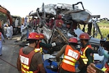 A Pakistani rescue team work on the wreckage of a deadly accident involving two buses.