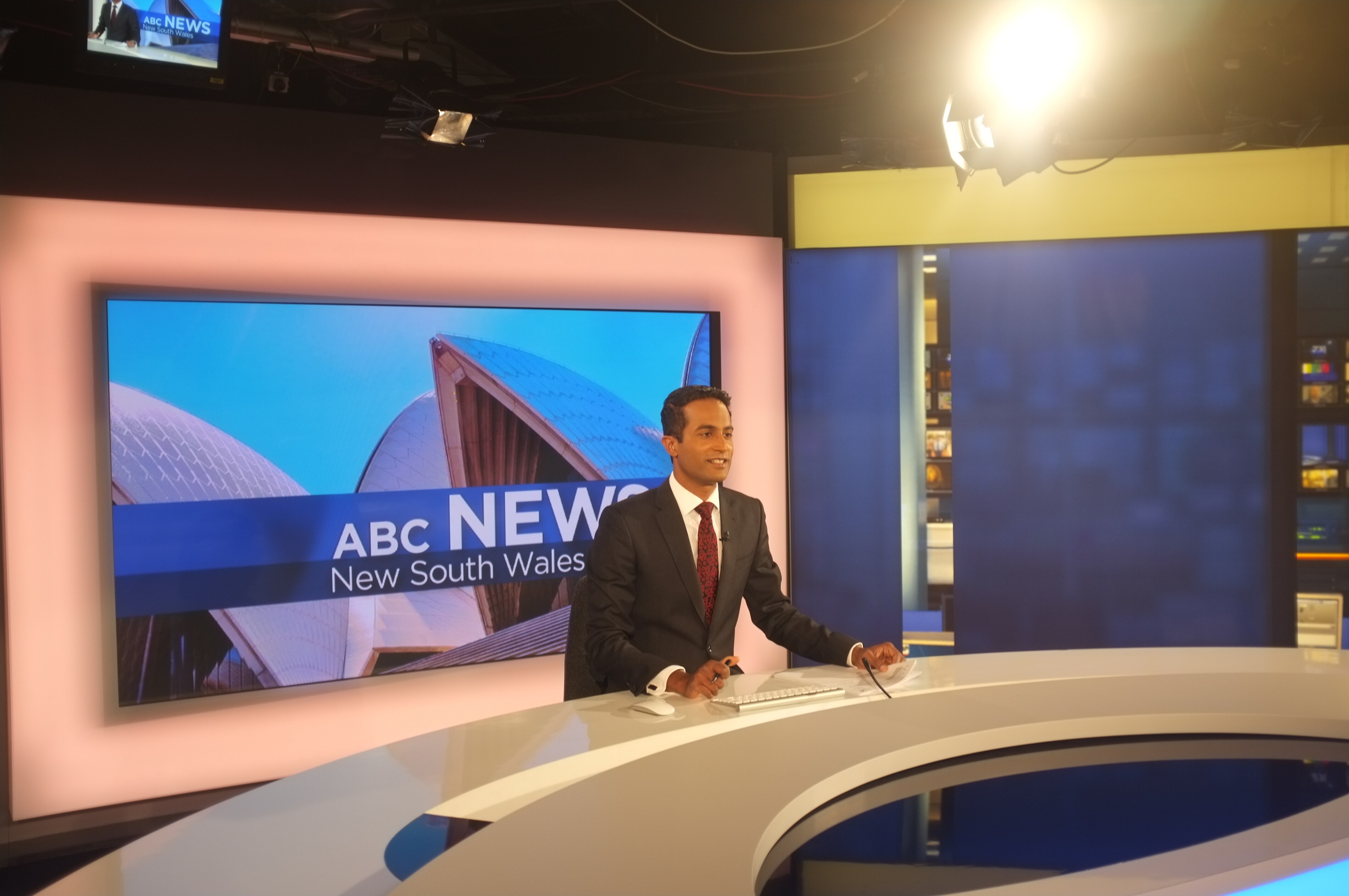 A man sits at a news desk