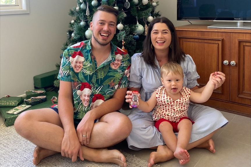 The Los family sit in front of their Christmas tree at home in Brisbane