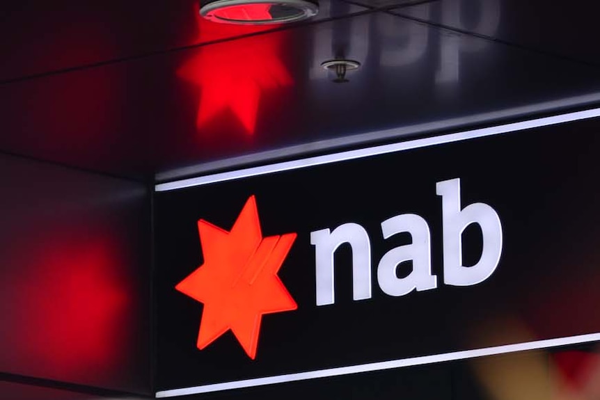 A man walks past an NAB ATM in Brisbane