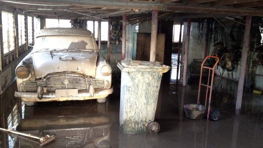 Jim Scott's silt-covered 1961 Zephyr dries off after the massive flood swamped Mitchell