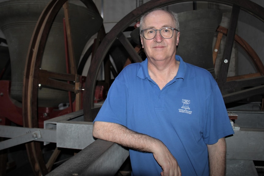 Doug Nichols stands next to church bells and apparatus.
