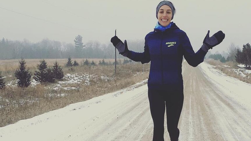 Middle-distance runner Gabriele Grunewald runs through the snow raising her hands.