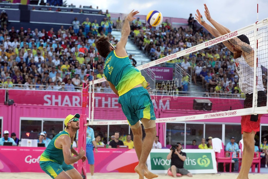 Australian volleyballer spikes against Canada.