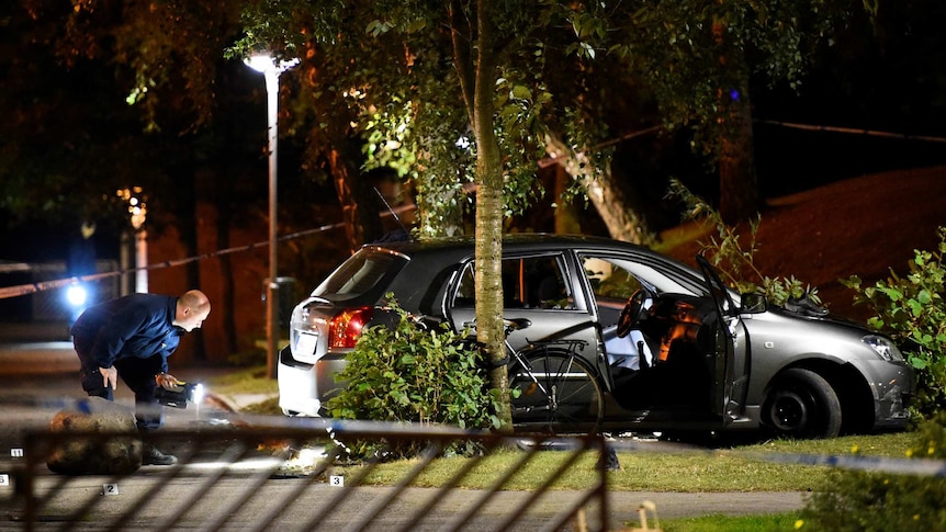 Forensic police examine a car crash scene