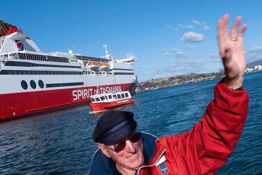 Ship's master Graham Kent waves to a passing boat