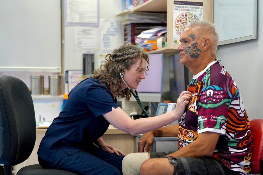 A doctor with a stethoscope listening a patient breathing