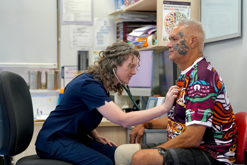A doctor with a stethoscope listening a patient breathing