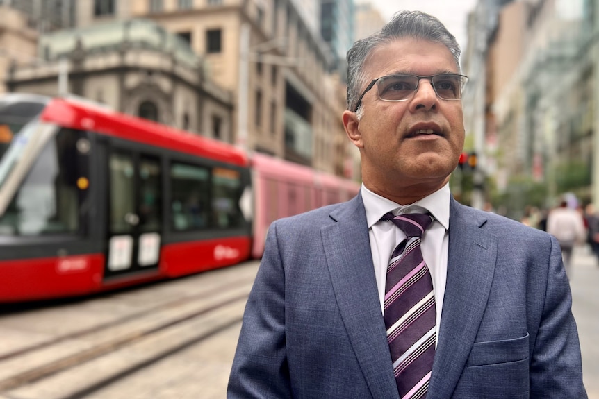 Man stands in Sydney near tram