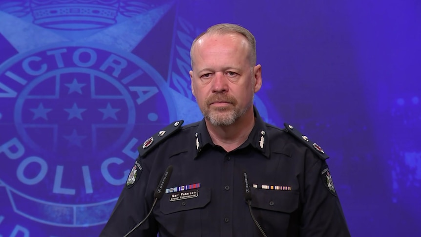 Policeman in uniform with Victoria Police backdrop