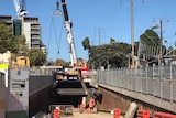 Crane lowers final roof plank into position for the Adelaide bus tunnel.