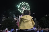 A young girl watches the early New Year's Eve