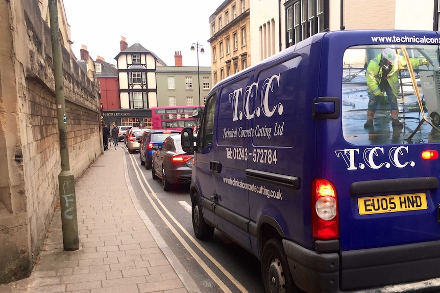 Traffic builds up amid old buildings during peak hour in Oxford.