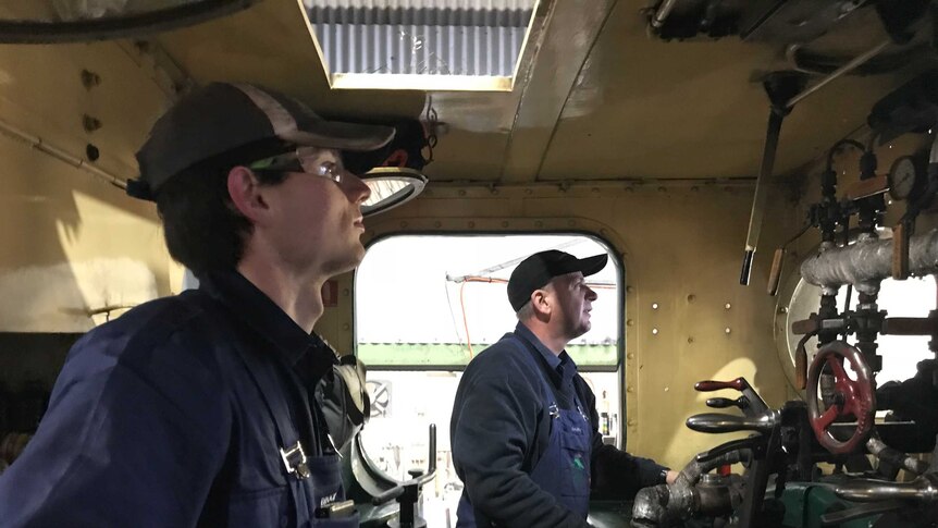 Trainee Brock Sutton with fireman Darren inside the cockpit of the steam train doing checks.