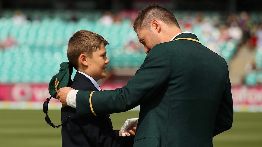 Touching moment ... Tony Grieg's son Tom presents Michael Clarke with his father's handkerchief.