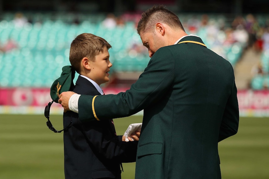 Touching moment ... Tony Grieg's son Tom presents Michael Clarke with his father's handkerchief.