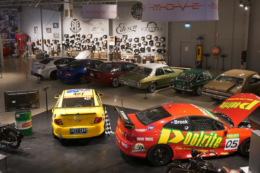 A birds eye view shot of some old cars and race cars in a car museum. 