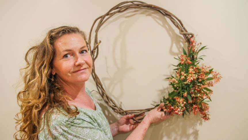 Bec holds a wreath she made from garden vines
