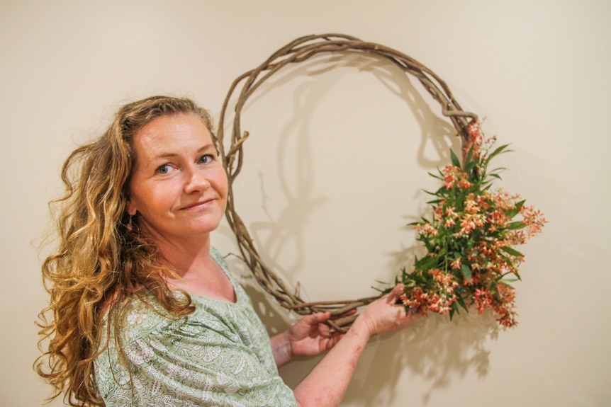 Bec holds a wreath she made from garden vines