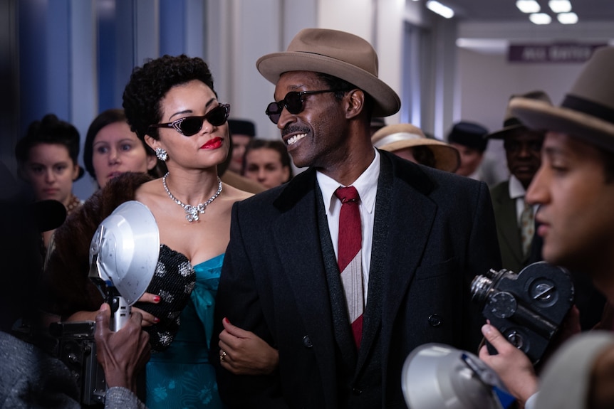 Film still of Andra Day as Billie Holiday and Rob Morgan as Louis McKay with paparazzi from The United States vs Billie Holiday