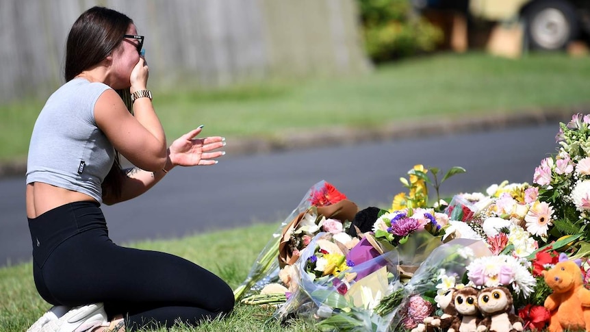 A friend of the victims named Korri Loader reacts at a makeshift shrine.