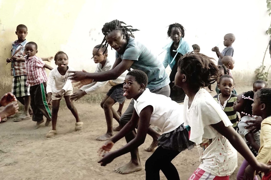 Alexx Mubanga dances with children in Zambia.