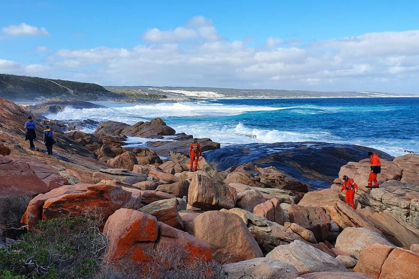 Rescue workers searching for a missing fisherman who was swept off the rocks.