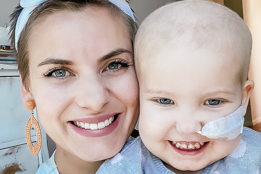 a mother and daughter smile at the camera