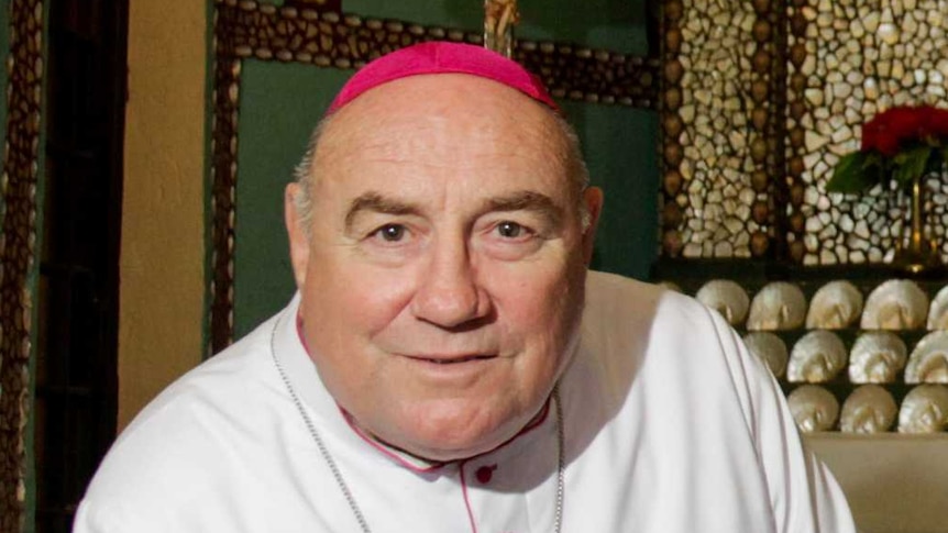 A bishop sits in front of an altar made of mother of pearl.