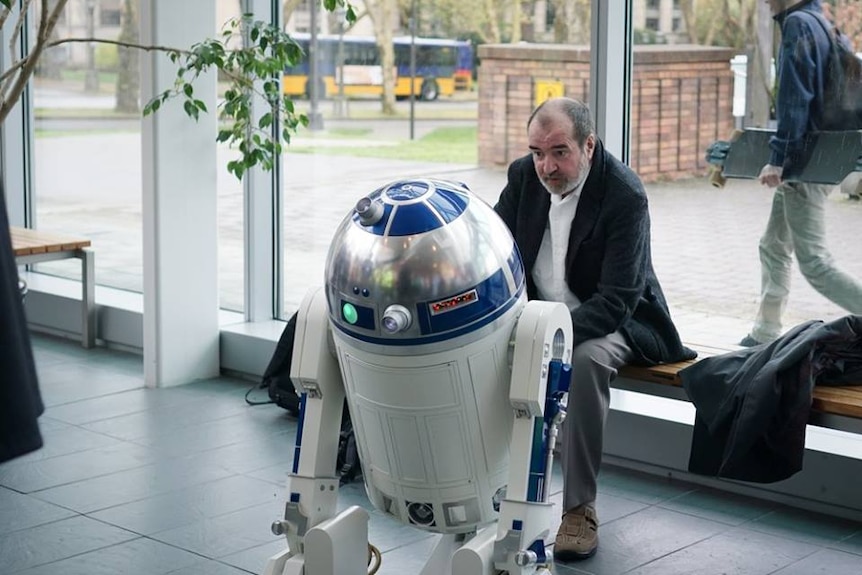 Tony Dyson, creator of Star Wars robot R2-D2, sits with a model of his creation