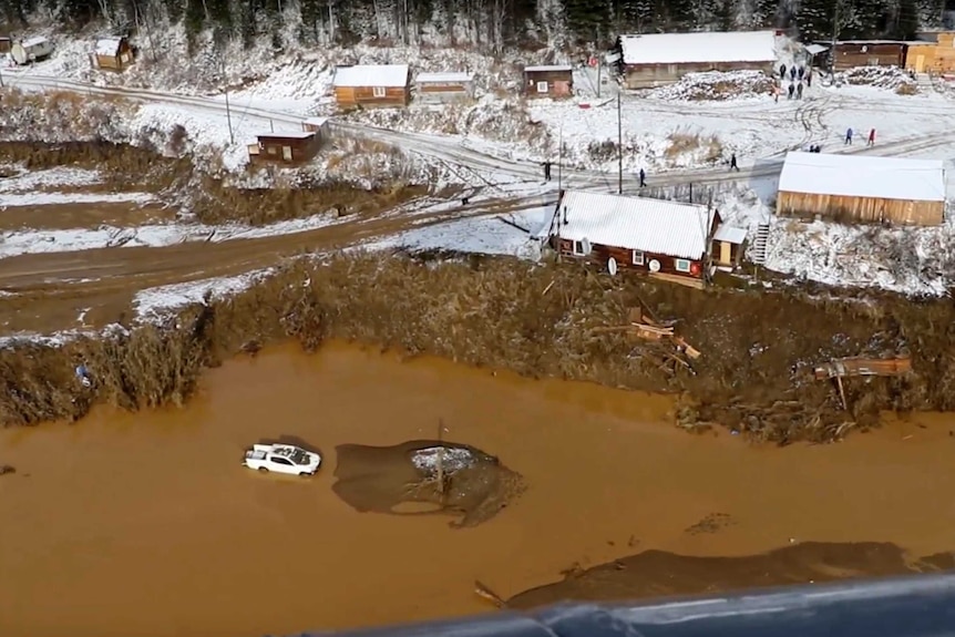 Ariel view of brown, muddy water that's the result of heavy rain across a small village