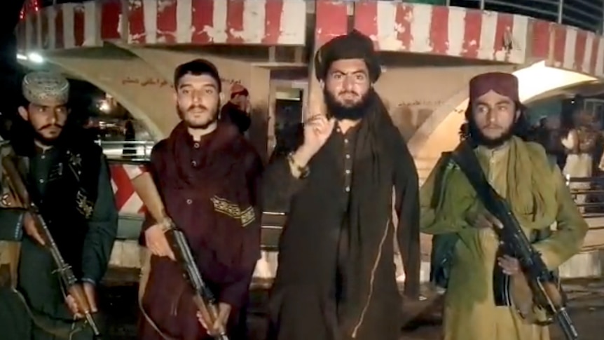 A video still showing armed men speaking.
