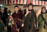 Taliban fighters stand with guns while record a video message