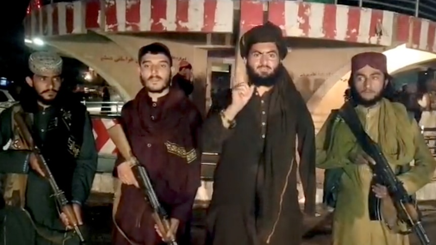 Taliban fighters stand with guns while record a video message